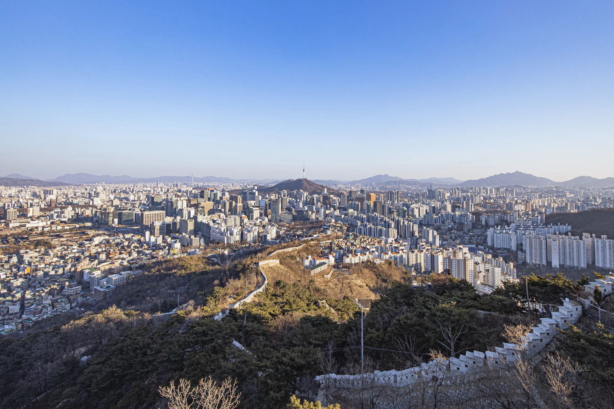 The Seoul City Wall follows Inwangsan ridge toward central Seoul under a clear blue sky